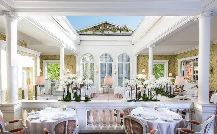 Elegant event space at Restaurant Lasserre with natural light and floral decor.