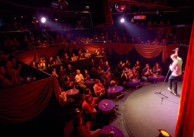 Vibrant Pleasance Theatre performance space with circular stage, ideal for comedy shows.