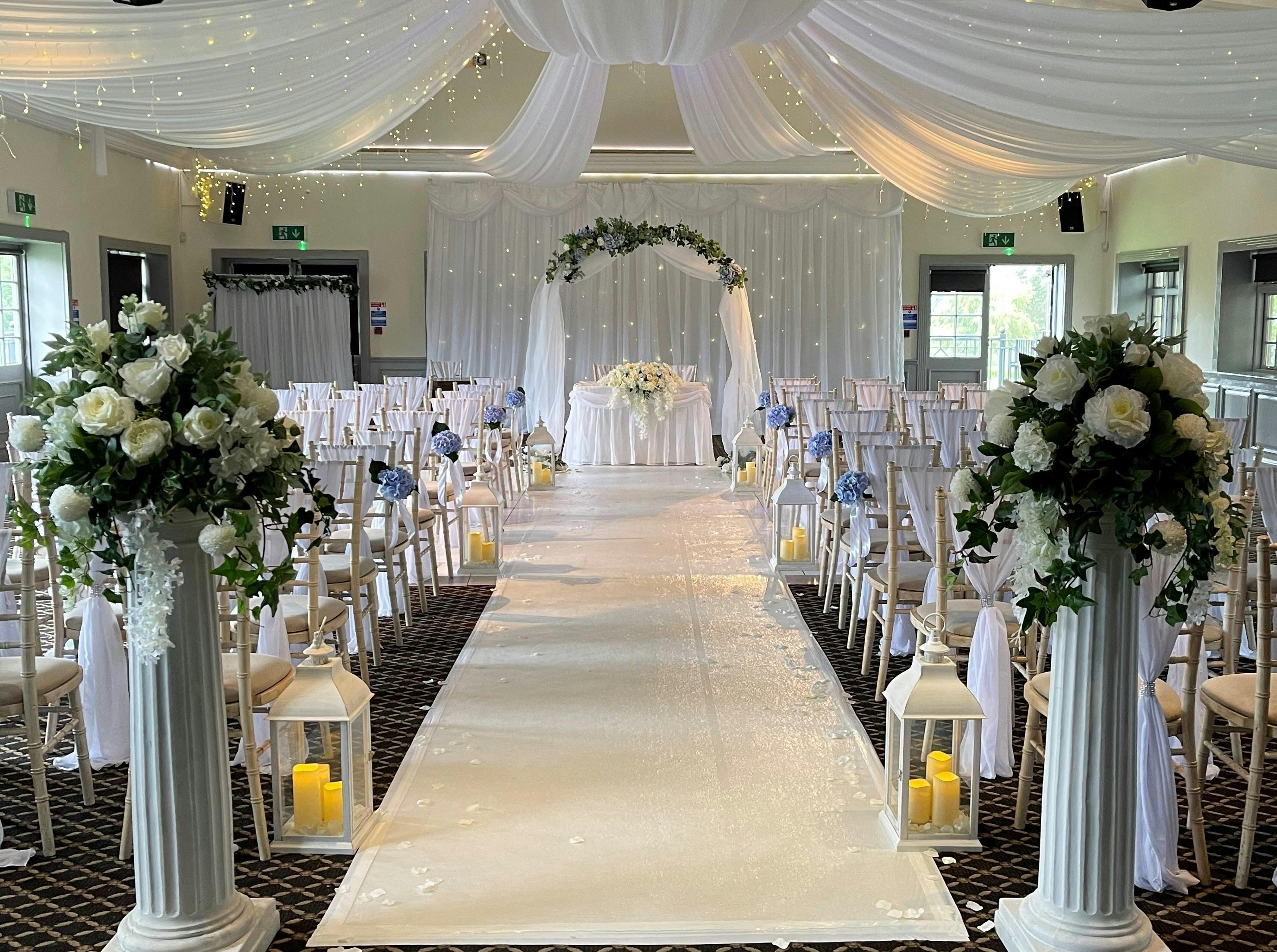 Elegant wedding ceremony setup in Taylor Suite, Woolston Manor with floral archway.