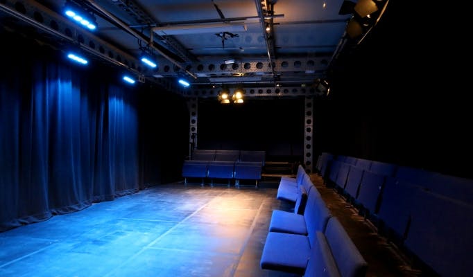 Intimate performance space at Pleasance Theatre with blue lighting for workshops and events.