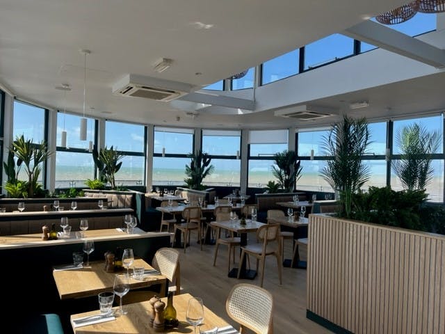 Modern Upstairs Restaurant with large windows, ideal for meetings and social events.