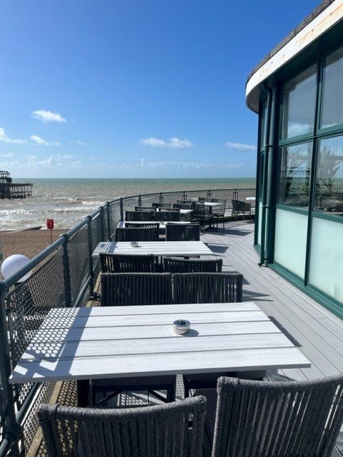 Outdoor terrace at Upstairs Restaurant, modern furniture, ideal for networking events by the sea.