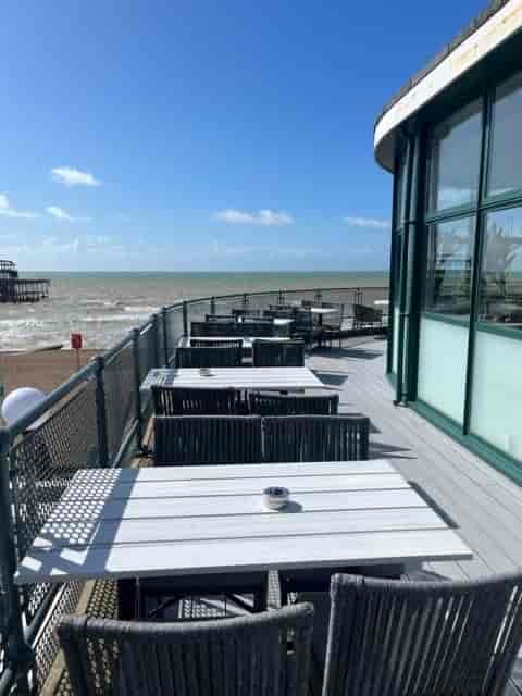 Outdoor terrace at Upstairs Restaurant, modern furniture, ideal for networking events by the sea.