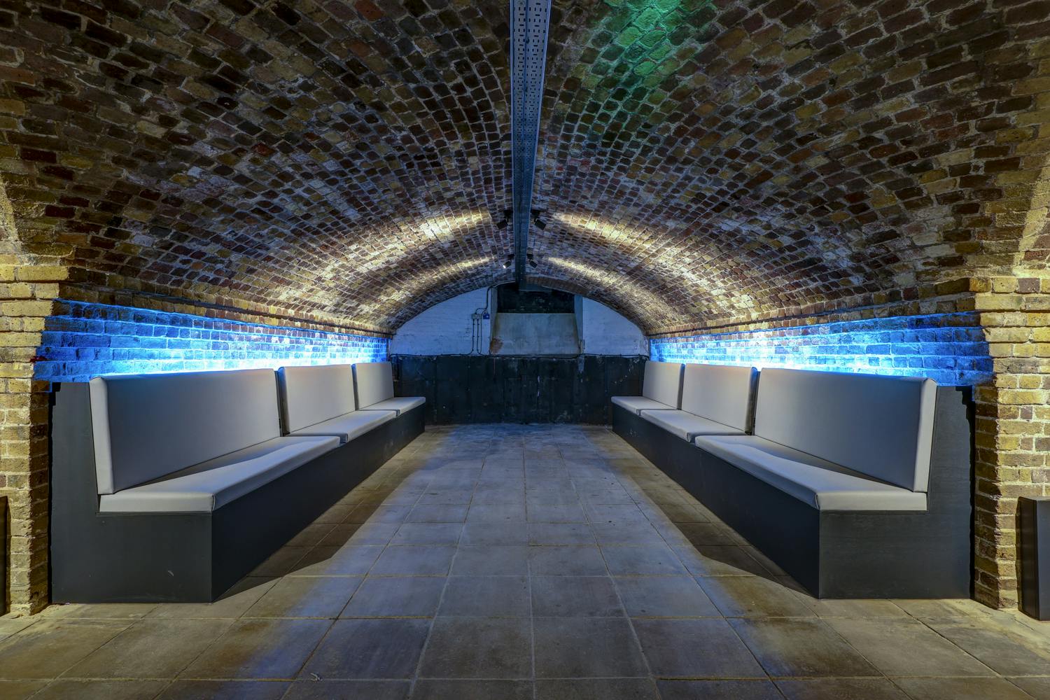 Underground venue with arched brick ceiling, perfect for intimate gatherings and events.