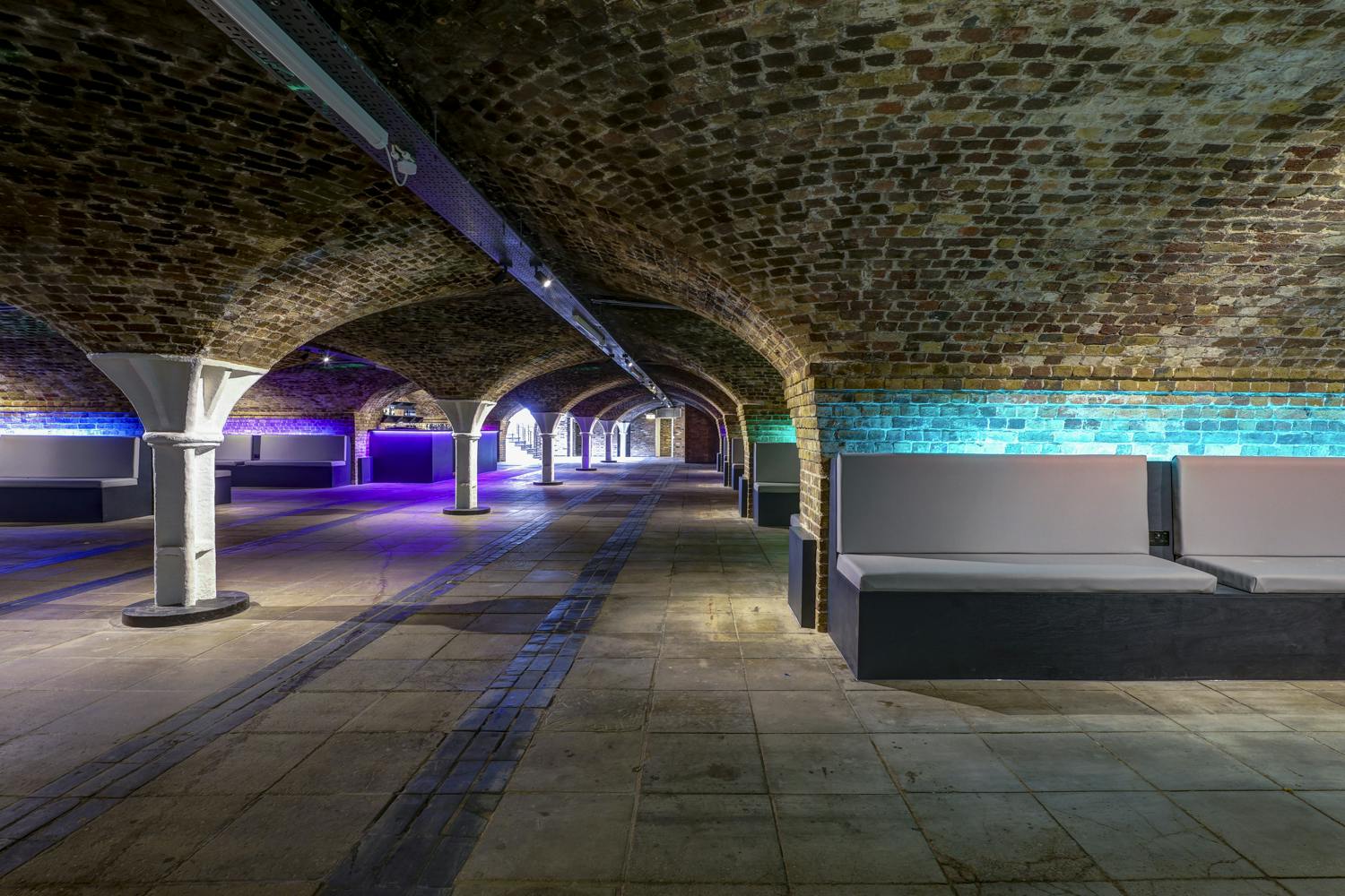 Underground venue with exposed brick arches for creative corporate events and art exhibitions.