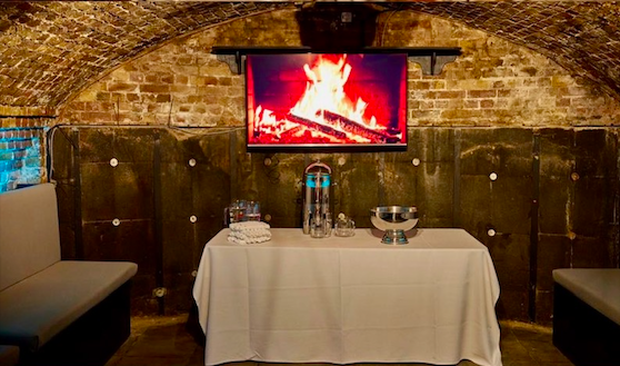 Cozy Dockside Vaults event space with digital fireplace for intimate gatherings.