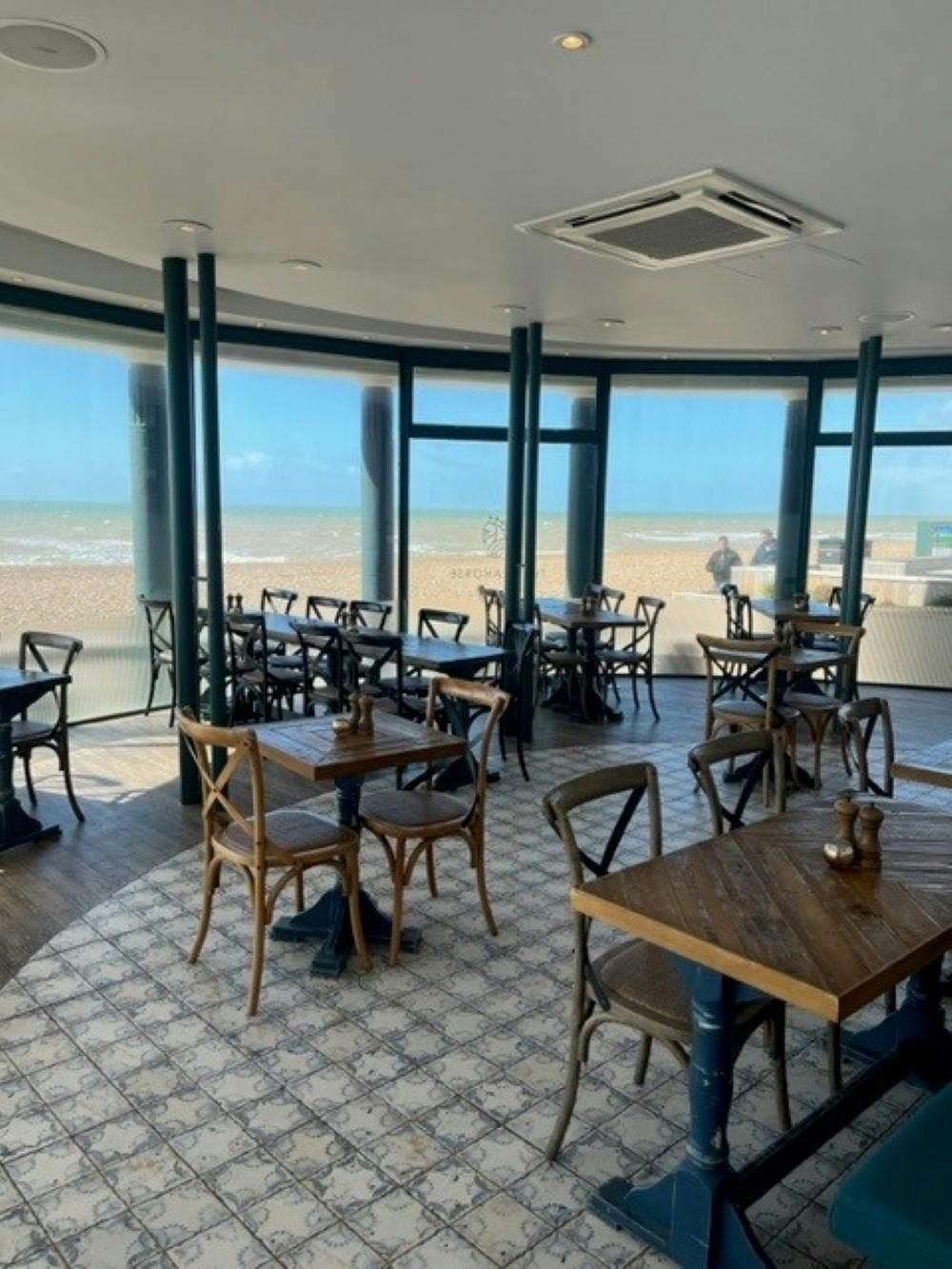 Stylish beachfront venue with wooden tables, ideal for meetings and events.