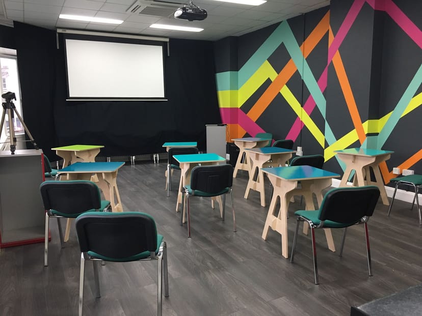 Modern TMS Meeting Room with colorful wall art, perfect for workshops and training events.