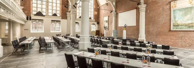 Olof's Chapelle conference venue with tables, chairs, and stage for events in Nhow Barbizon Palace.