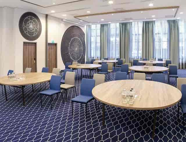 Modern meeting room with round tables for workshops in Radisson Blu Amsterdam.