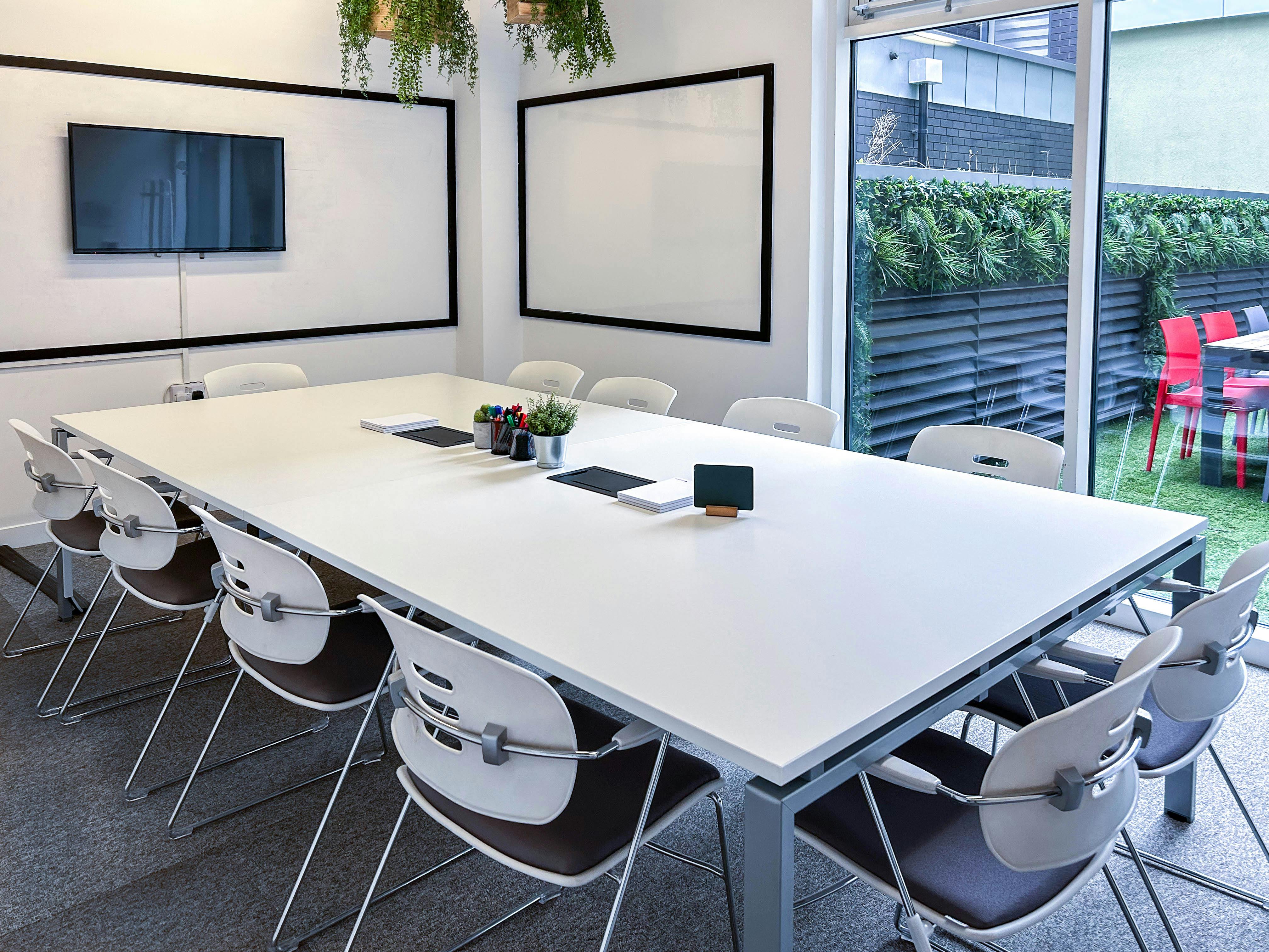 Modern meeting room with large white table, ideal for brainstorming and presentations.