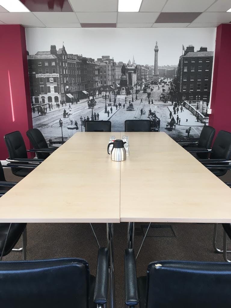 Modern meeting room with large table and cityscape backdrop for collaborative events.