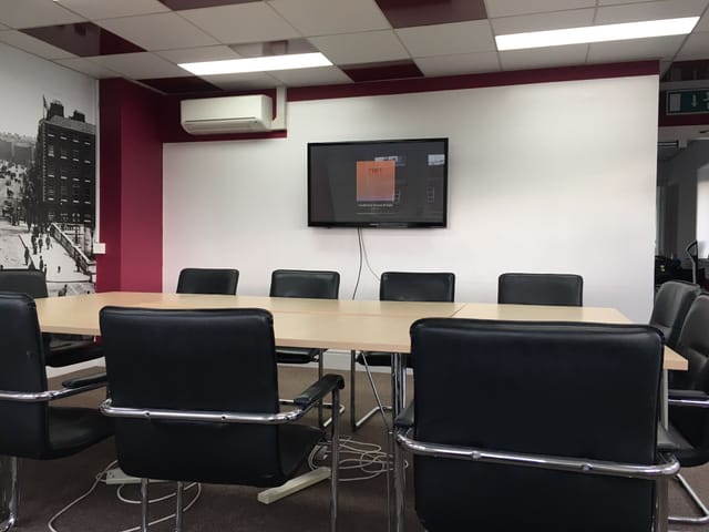 Modern meeting room with large table and ergonomic chairs for collaborative discussions.