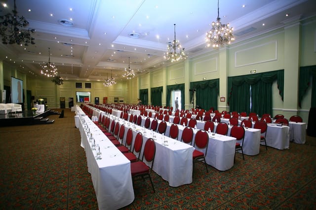 Conference setup at Indaba Hotel with white tables and red chairs for formal events.