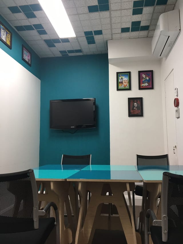 Modern kBone Meeting Room with teal wall, glass table for coworking events.