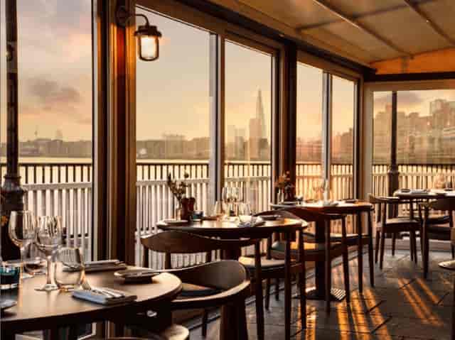 Elegant dining space with waterfront view at sunset, perfect for upscale events.