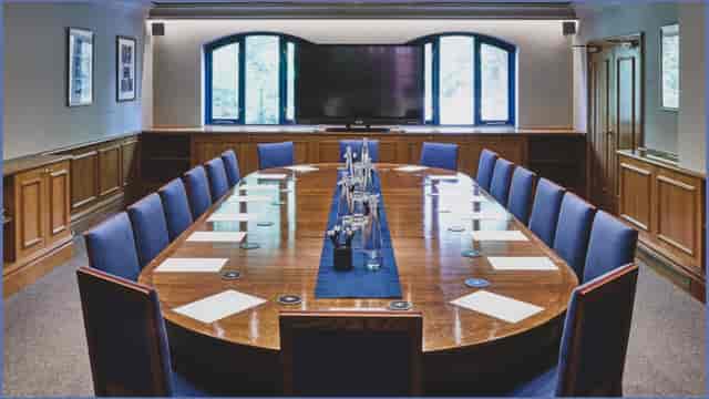 Boardroom at Queen's Club with polished table, ideal for meetings and presentations.