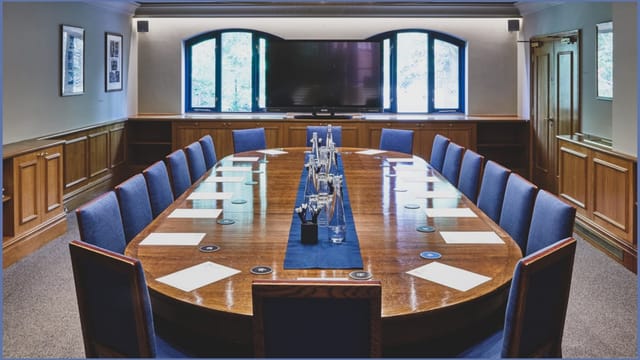 Boardroom at Queen's Club with polished table, ideal for meetings and presentations.
