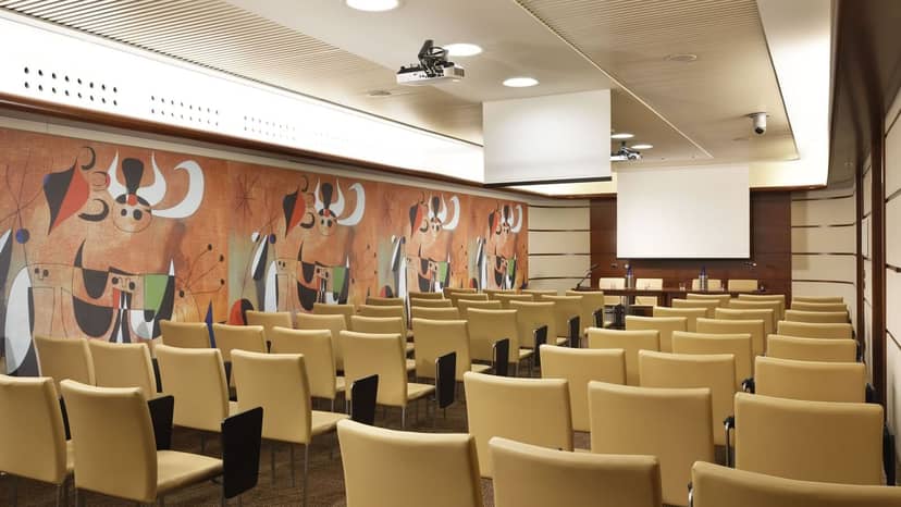 Modern conference room with beige chairs and vibrant mural at Una Hotels Casa Milano.
