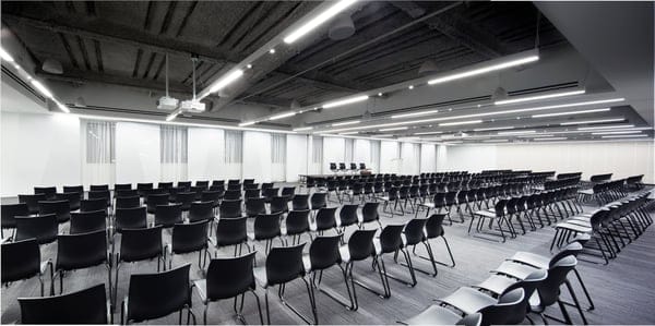 Full Buyout at Convene: modern event space with black chairs for conferences and presentations.