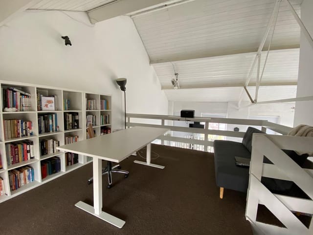 Industrial loft event space in High Barnet with sleek table, ideal for meetings and brainstorming.
