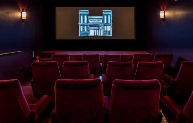 Cozy screening room with plush red seating for private film events and corporate meetings.