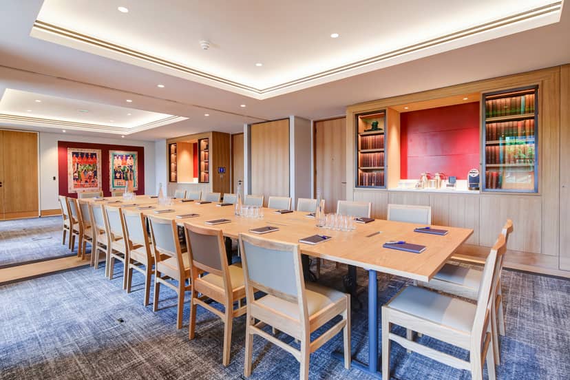 Meeting room with long table, warm wood tones for professional gatherings.