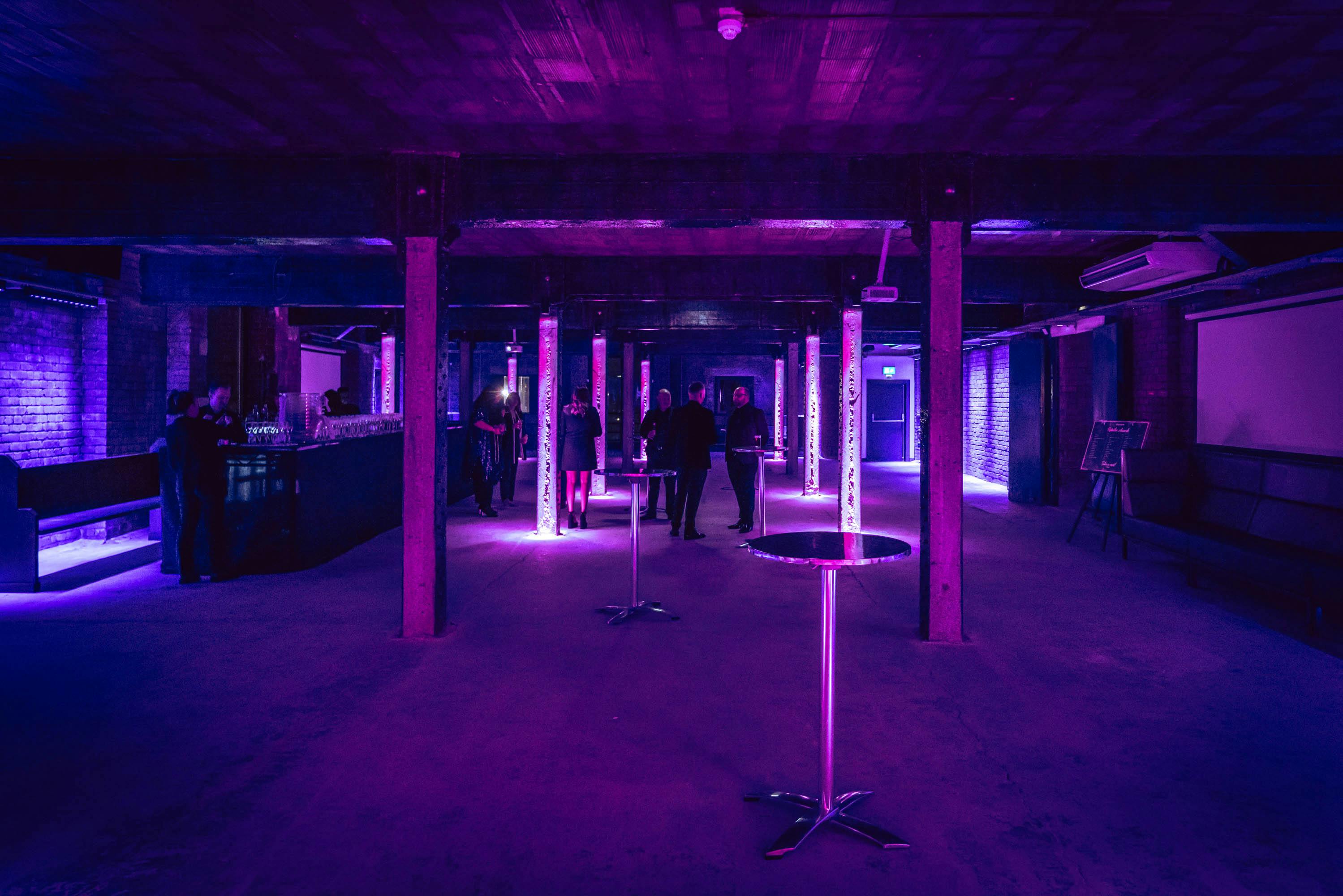 Versatile event space at Tobacco Stores, featuring purple lighting for cocktail receptions.