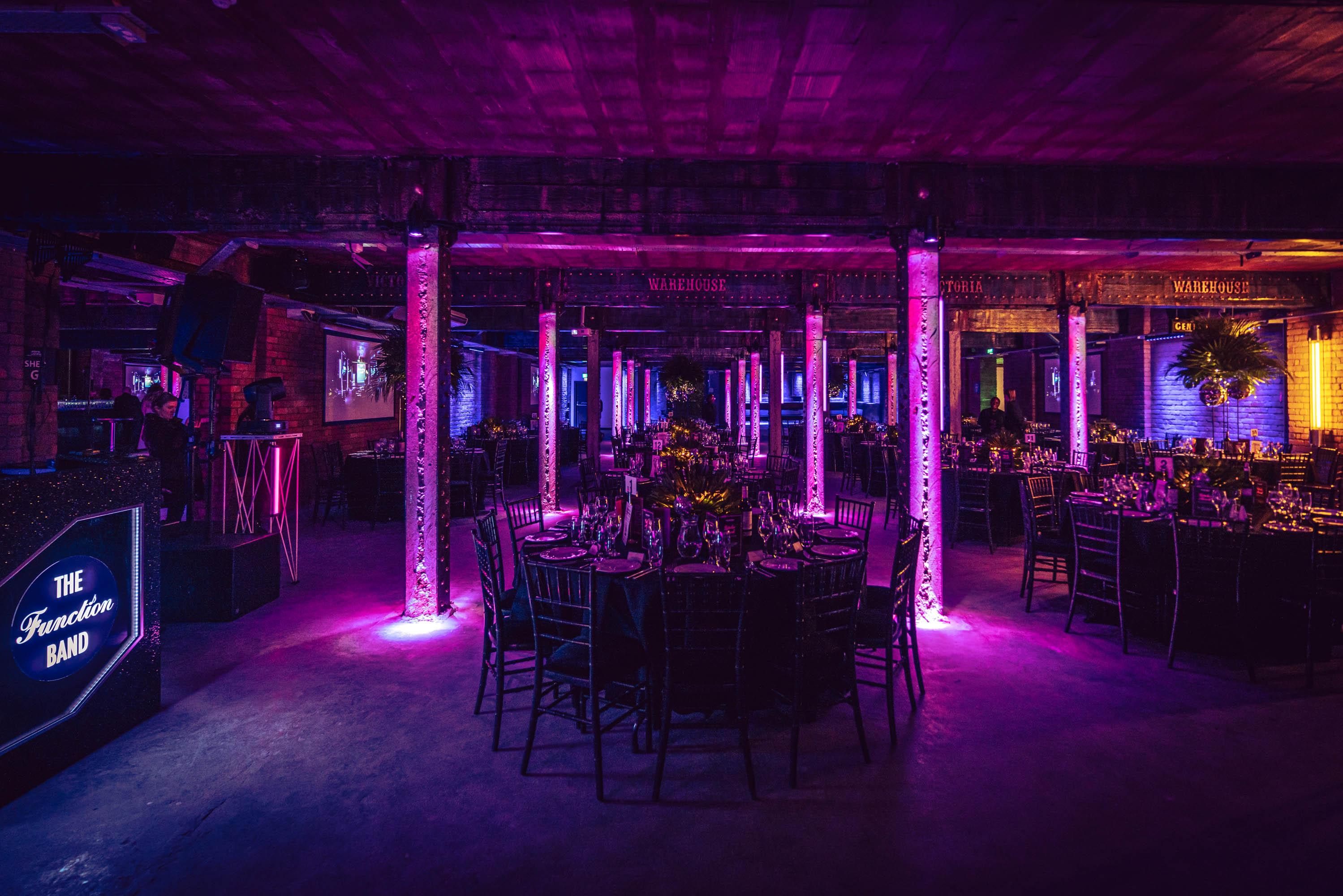 Elegant event space at Tobacco Stores with round tables and vibrant lighting.