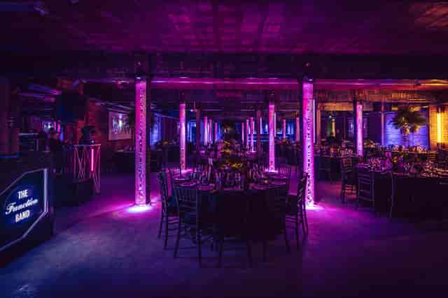 Elegant event space at Tobacco Stores with round tables and vibrant lighting.