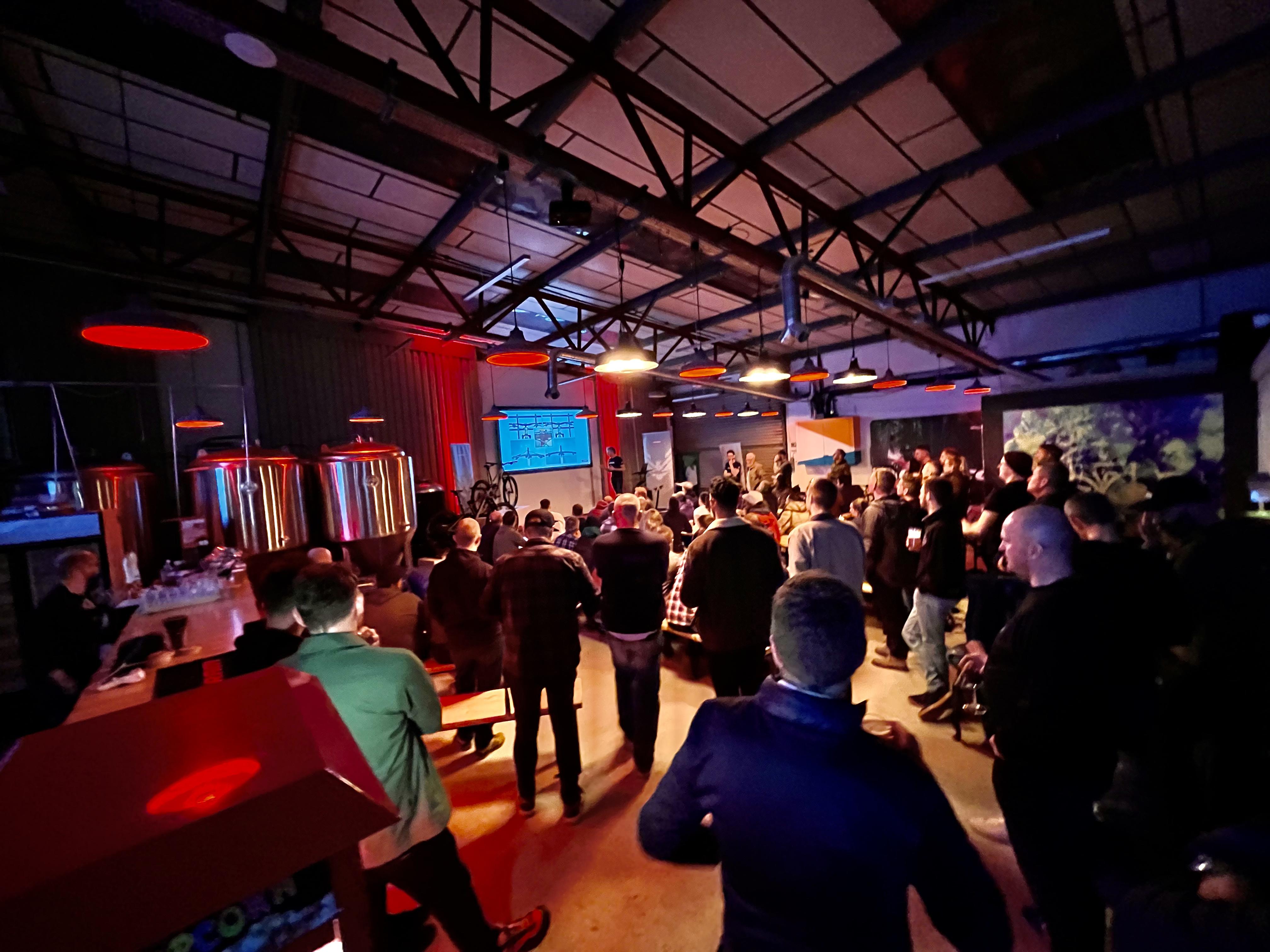 Brewery event space with attendees at a presentation in Halton Turner Brewing Co. - Banner