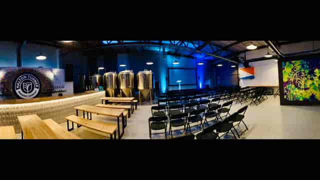 Brewery event space with bar and seating, ideal for corporate events and gatherings.