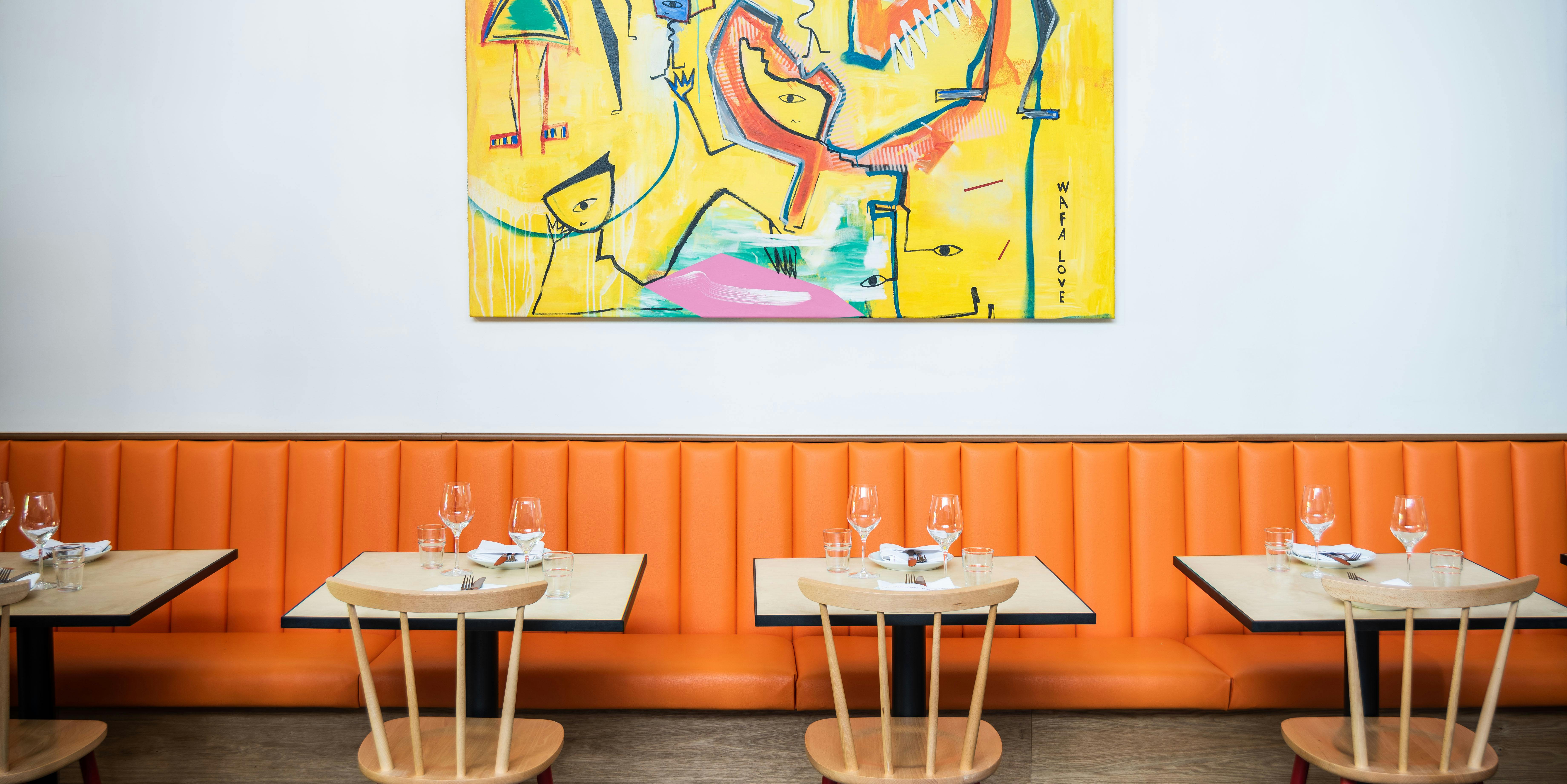 Vibrant dining space with orange banquette for networking events in Hackney Coterie.