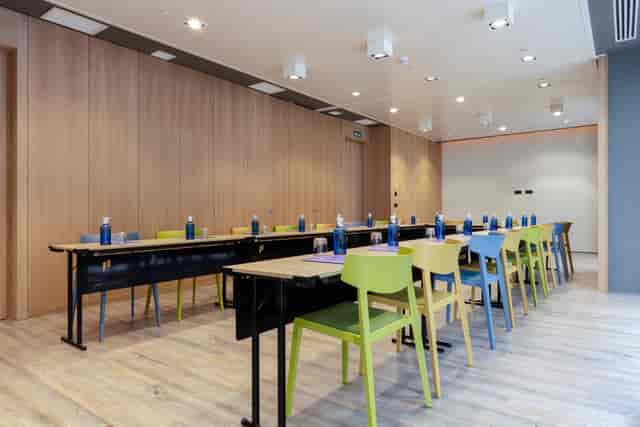 Modern meeting room with colorful chairs at Pestana CR7, perfect for workshops and brainstorming.