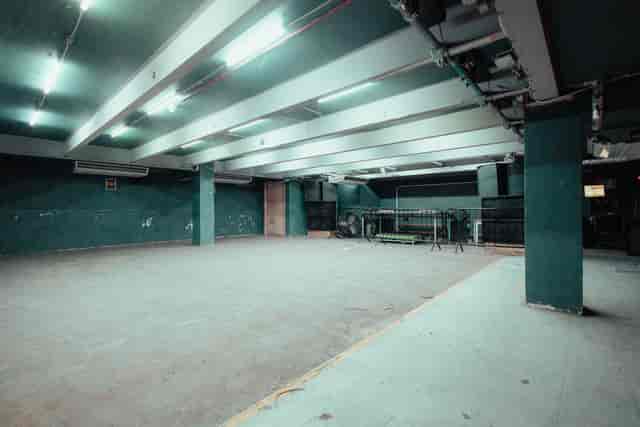 Spacious minimalist event venue with exposed beams, ideal for customizable gatherings.