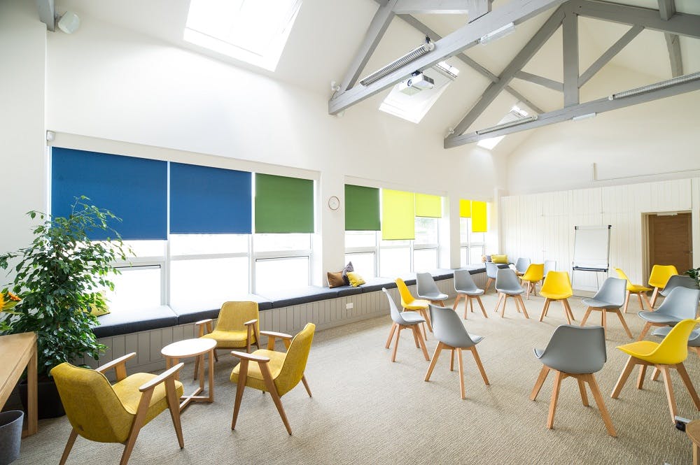 Bright meeting space with colorful chairs for workshops and brainstorming sessions.