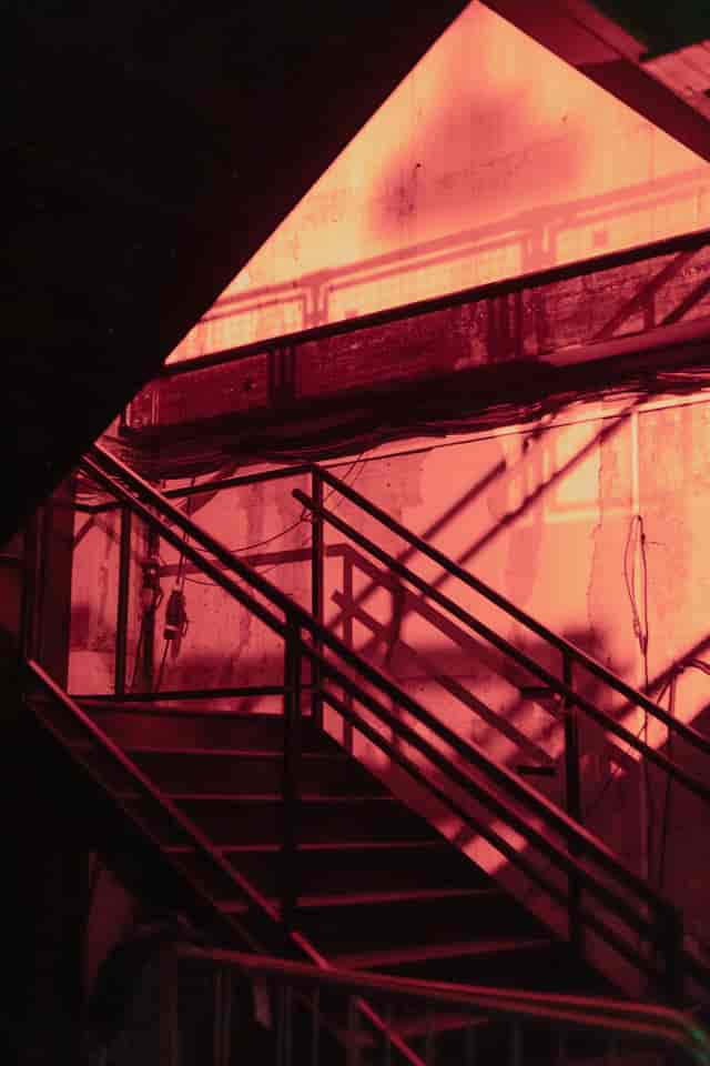 Industrial staircase with red lighting at Warehouse in The Cause, ideal for creative events.