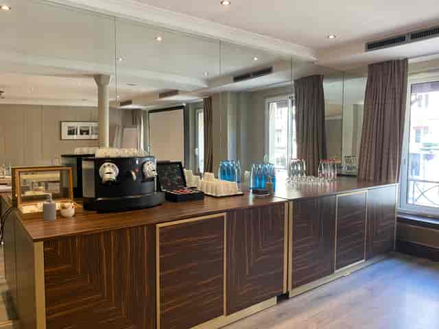 Elegant meeting space at Hotel Edouard 7 with polished wooden refreshment station.
