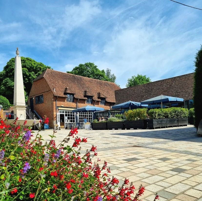 Charming outdoor venue at Coach House Kitchen with blue umbrellas for events in Hatfield House.