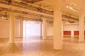 Spacious event venue with high ceilings, ideal for corporate meetings and art exhibitions.