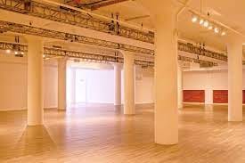 Spacious event venue with high ceilings, ideal for corporate meetings and art exhibitions.