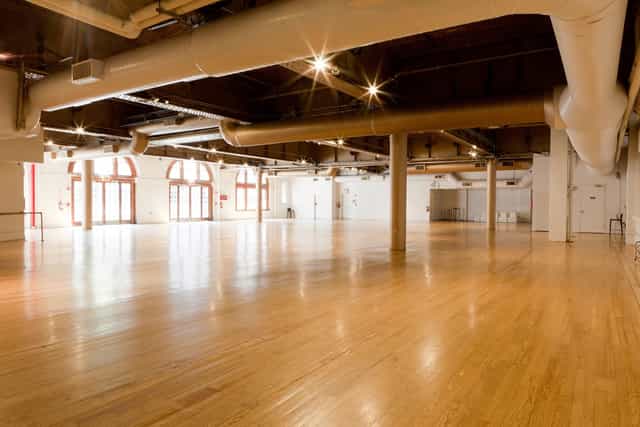 Spacious event venue with polished floors, ideal for conferences and gatherings.