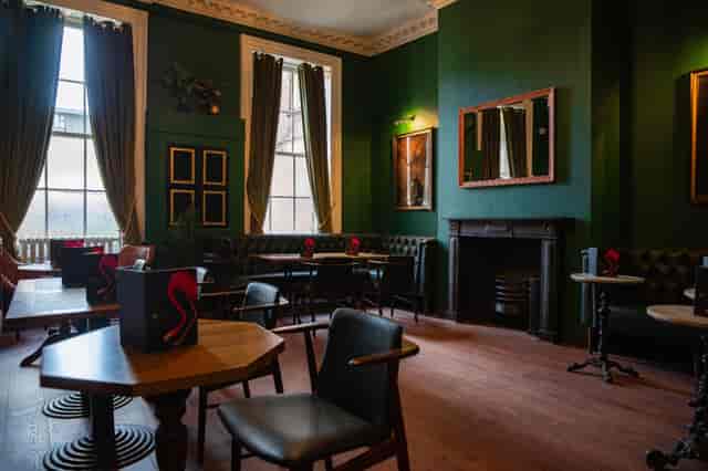 Stylish meeting space with green walls, perfect for gatherings and workshops.