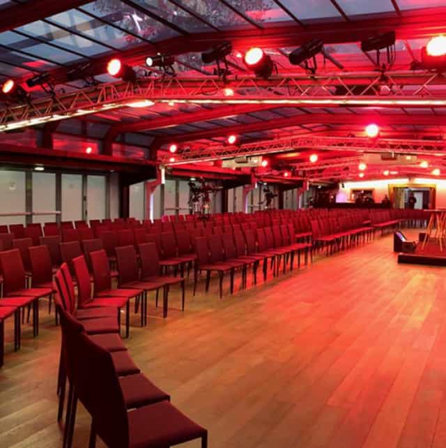 Spacious Les Salons Nework venue with red lighting for conferences and presentations.