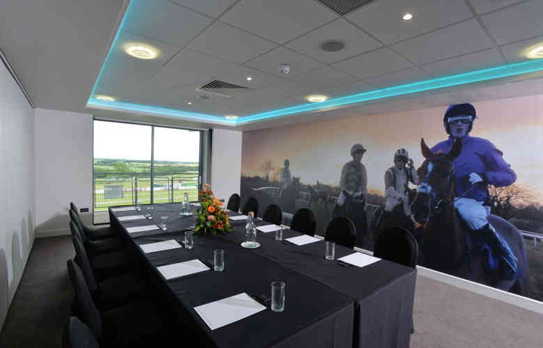 Modern meeting room at Carlisle Racecourse with horse racing mural for corporate events.