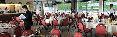 Nottingham Racecourse banquet setup with round tables and red chairs for corporate events.