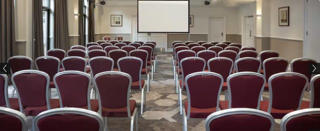 Meeting space in Hilton York with burgundy chairs for presentations and workshops.