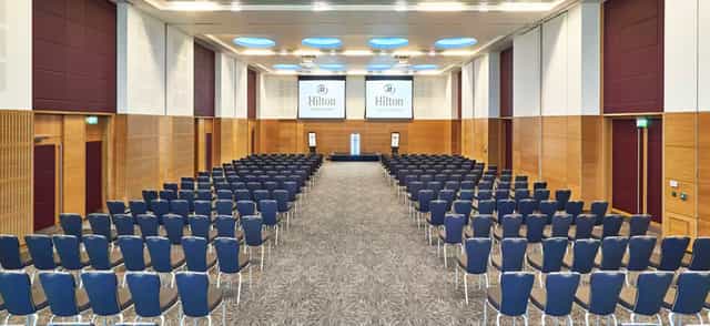 Sir Bobby Robson Ballroom conference setup with screens for corporate events, spacious and modern.