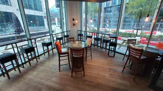 Modern meeting space with round glass table at Veeno Italian Wine Bar, Leeds.