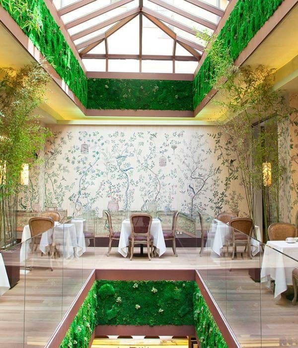 Elegant dining space at Urso Hotel with nature mural, ideal for upscale events.